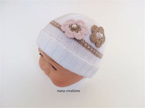 Bonnet bébé tricoté en laine layette et ses fleurs au crochet blanc