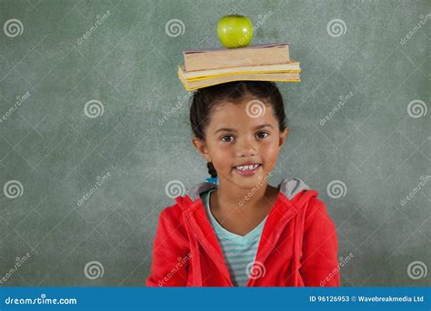 Libros Y Manzana De Equilibrio De La Chica Joven En Su Cabeza Imagen De