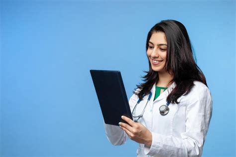 Médica linda jovem asiática um laptop para registros isolados em