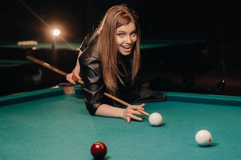 Premium Photo A Girl With A Cue In Her Hands Makes A Shot At A Ball