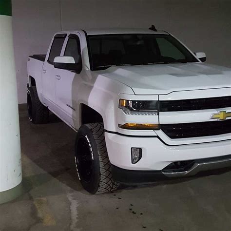 White Lifted Chevy Truck In Garage