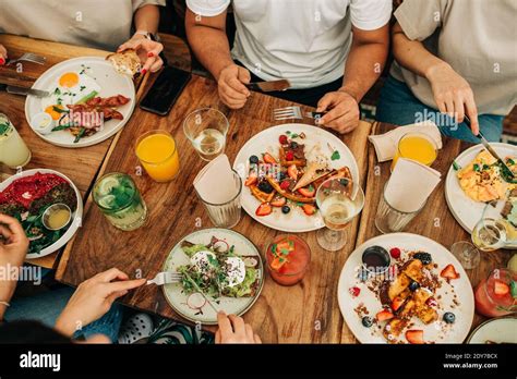 Group Of People Eating Breakfast Or Brunch At Table In Cafe Stock Photo