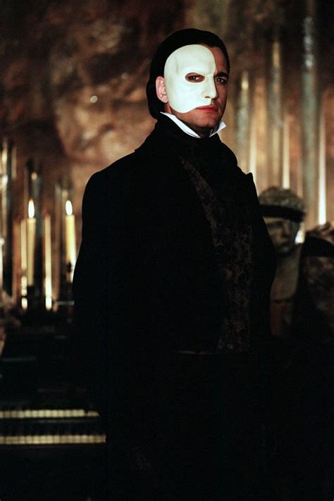 A Man Wearing A White Mask And Black Coat