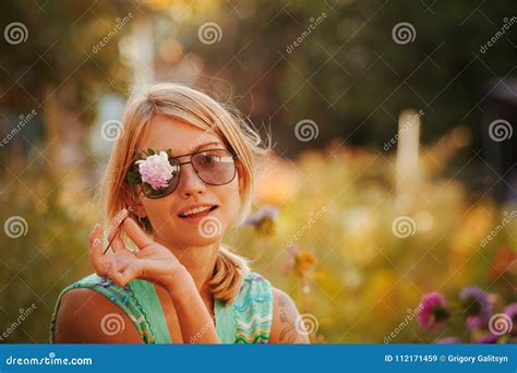 La Fille Dans Des Lunettes De Soleil Tient Une Fleur Devant Son Visage