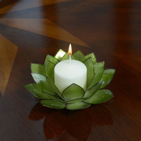 A Lit Candle Sitting On Top Of A Leafy Flower Shaped Bowl With Leaves