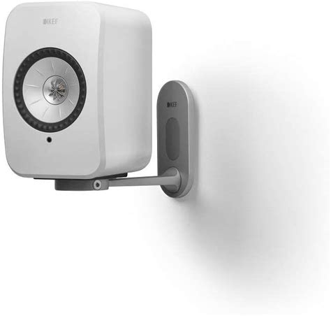 a white speaker mounted to the side of a wall with a metal hook on it