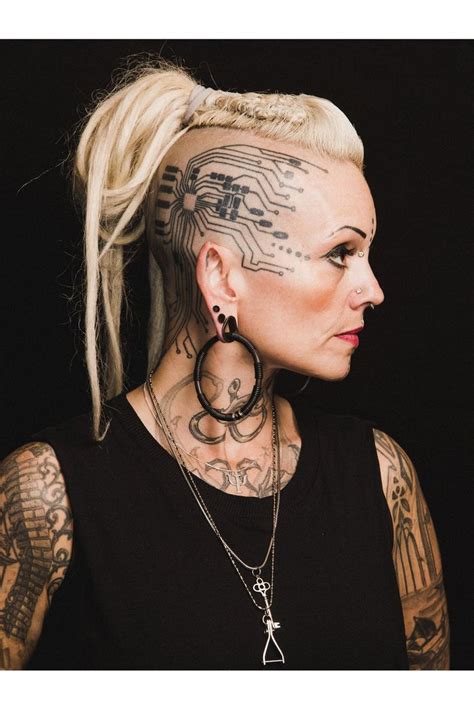 A Woman With Tattoos And Piercings On Her Head