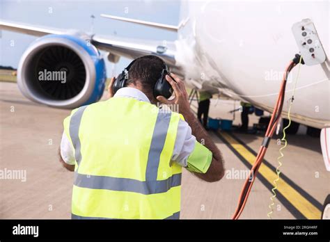 Worker Wearing Ear Muffs By Airplane Stock Photo Alamy