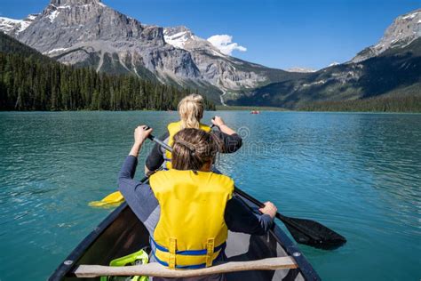 Two Women Paddle On A Canoe On Emerald Lake In Yoho National Park