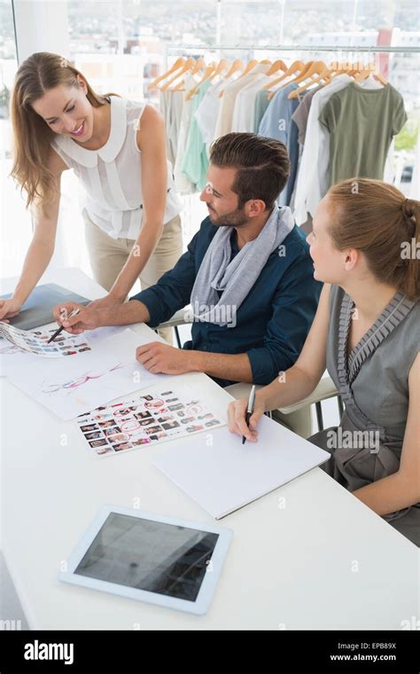 Three Fashion Designers Discussing Designs Stock Photo Alamy