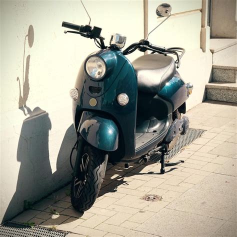 Premium Photo Motor Scooter Parked Against Wall With Shadow