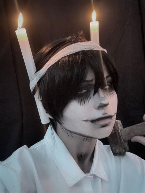 A Man With White Makeup And Candles On His Head Is Holding A Pair Of