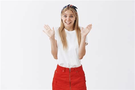 Mignonne Jeune Fille Blonde Maladroite Posant Contre Le Mur Blanc Photo Gratuite