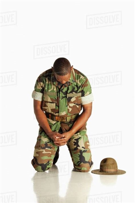 A Military Man Kneeling With His Head Bowed In Prayer Stock Photo