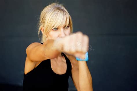 Focused Young Female Fighter Performing Martial Art Punches In Fitness