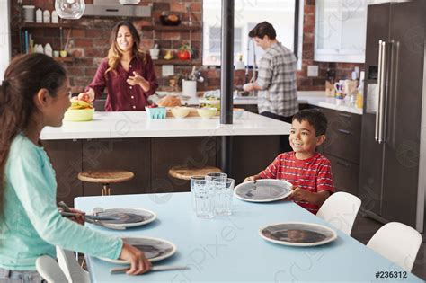 Niños que ayudan a poner la mesa listos para foto de stock 236312