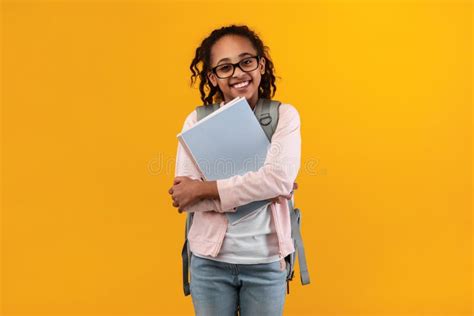 Cheerful Young Black Girl Holding Textbooks Looking At Camera Stock