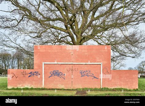 Football Goal Post Fixed To A Red Painted Wall In Front Of A Mature Oak