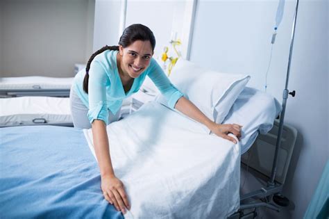 Premium Photo | Portrait of doctor preparing bed for patient