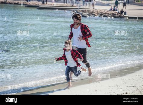 Father And Son Running Along Beach Stock Photo Alamy