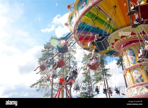 Colorful Chain Swing Carousel In Motion At Amusement Park On Blue Sky