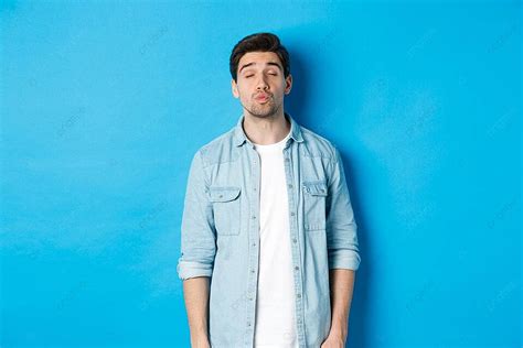 Blue Background Sets The Stage For A Charming Man Ready To Receive A