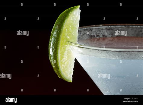 lime wedge on the rim of a martini glass used as a garnish isolated on a black background Stock ...