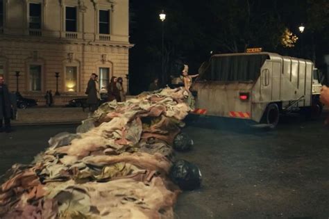 people standing on the side of a road next to a truck and pile of garbage