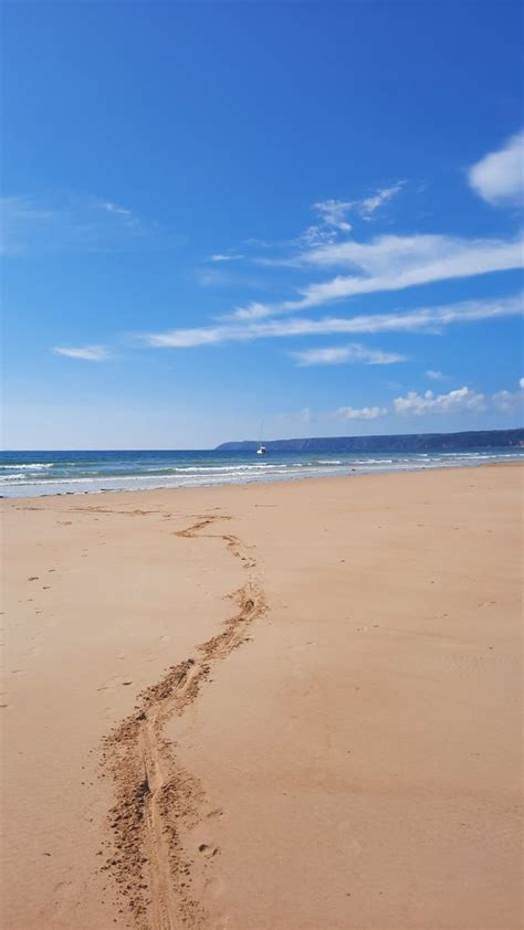 A Sandy Beach With Footprints In The Sand