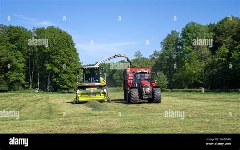 Tractor With Trailer Running Beside Claas Jaguar 870 Forage Harvester