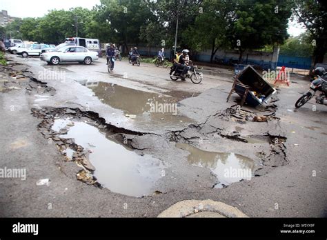 Karachi Pakistan Th July People Ride Past A Damaged Road