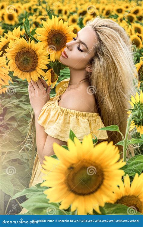 Beautiful Young Woman In A Field Of Sunflowers In A Yellow Dress Stock