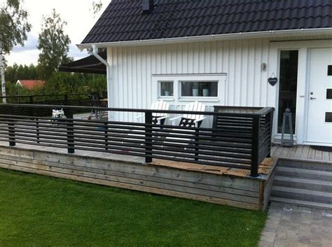 A White House With Black Railings And Grass