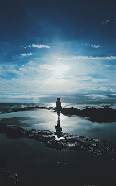 Premium Photo Silhouette Woman Standing On Shore At Beach Against Sky