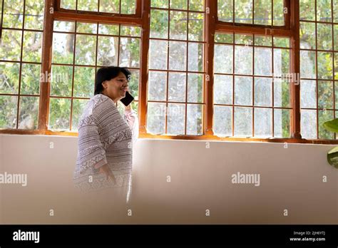 Side View Of Biracial Mature Woman Talking Over Mobile Phone While