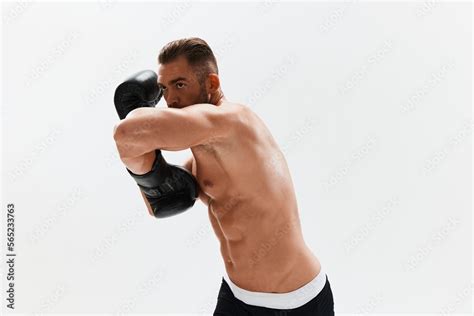 Man Athletic Bodybuilder Poses In Boxing Gloves With Nude Torso Abs In Full Length Background