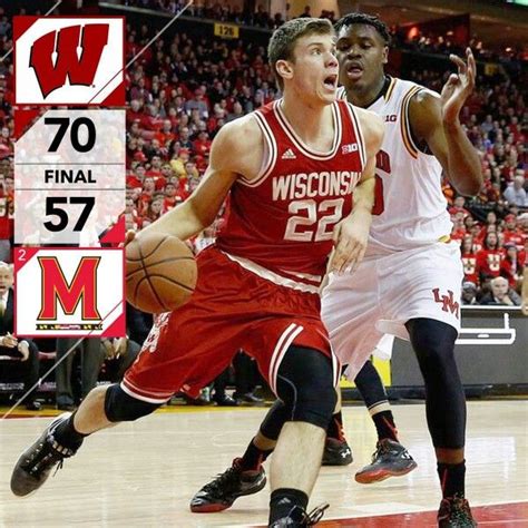 Two Men Playing Basketball In Front Of An Audience With The Scoreboard