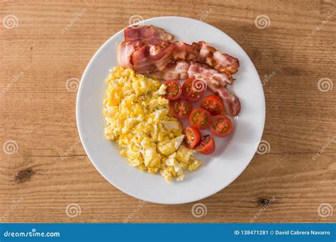 Breakfast With Scrambled Eggs Bacon And Tomatoes On Wooden Table Stock