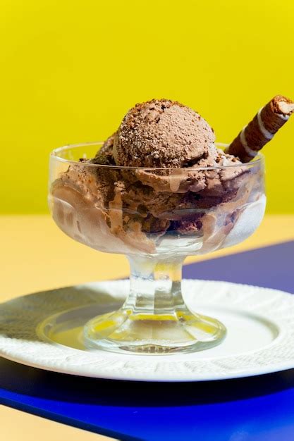 Premium Photo A Glass Bowl Of Chocolate Ice Cream With A Stick Of