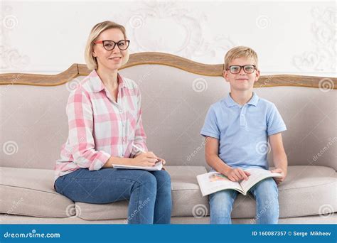 Cute Tutor In Nice Shirt And Happy Young Boy Wearing Blue Shirt Sit On