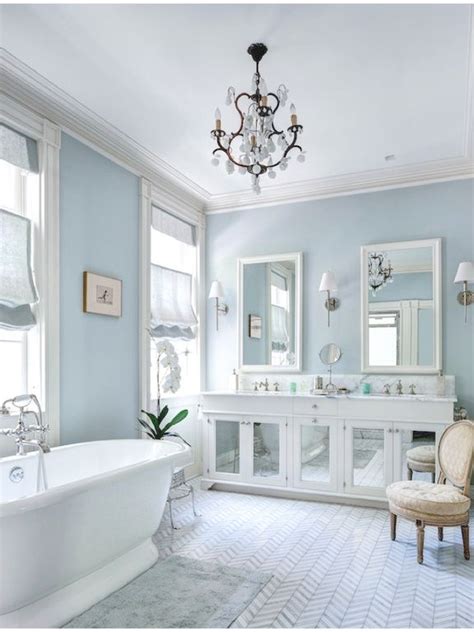 Soft sky blue walls embrace white cabinetry and large pedestal tub in ...