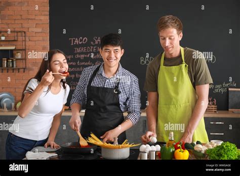 Happy Friends Cooking Together In Kitchen Stock Photo Alamy