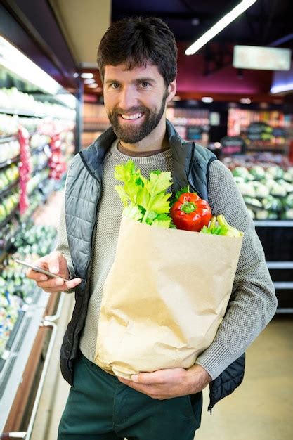 Retrato De Hombre Sonriente Sosteniendo Una Bolsa De Supermercado En La