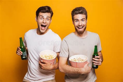 Amigos De Los Hombres Que Beben La Cerveza Que Come Las Palomitas Foto