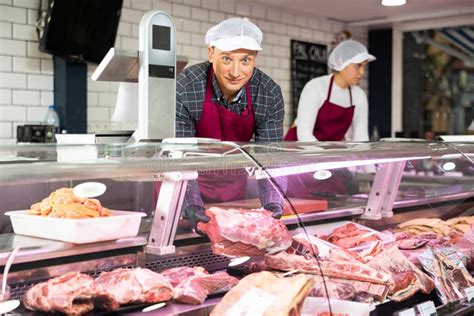 Happy Male Butcher Holding Big Chunk Of Beef Meat In Meat Section Of