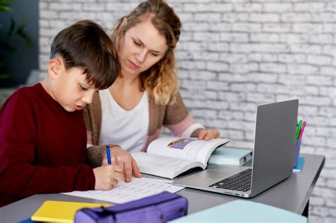 Madre Ayudando A Su Hijo Con Los Deberes Escolares Foto Premium