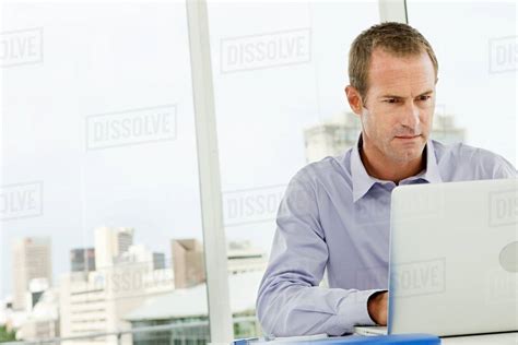 Businessman Using Laptop In Office Stock Photo Dissolve