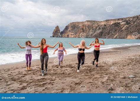 A Group Of Five Female Friends Are Doing Exercises On The Beach Beach