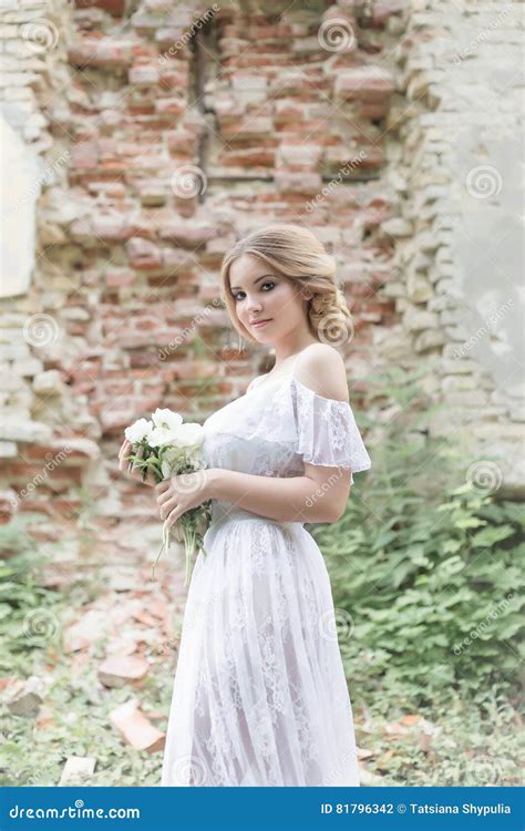 La Belle Jeune Fille Blonde Douce Avec Le Bouquet De Mariage Dans Les Mains Du Boudoir Dans Une
