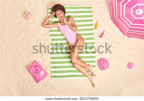 Entspannte dunkelhäutige Frau in rosafarbenem Bikini Stockfoto